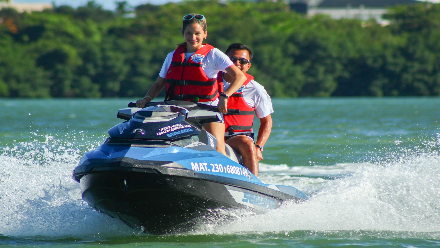 Father and daughter are riding a jet ski through the canals of the Nichupte Lagoon in Cancun